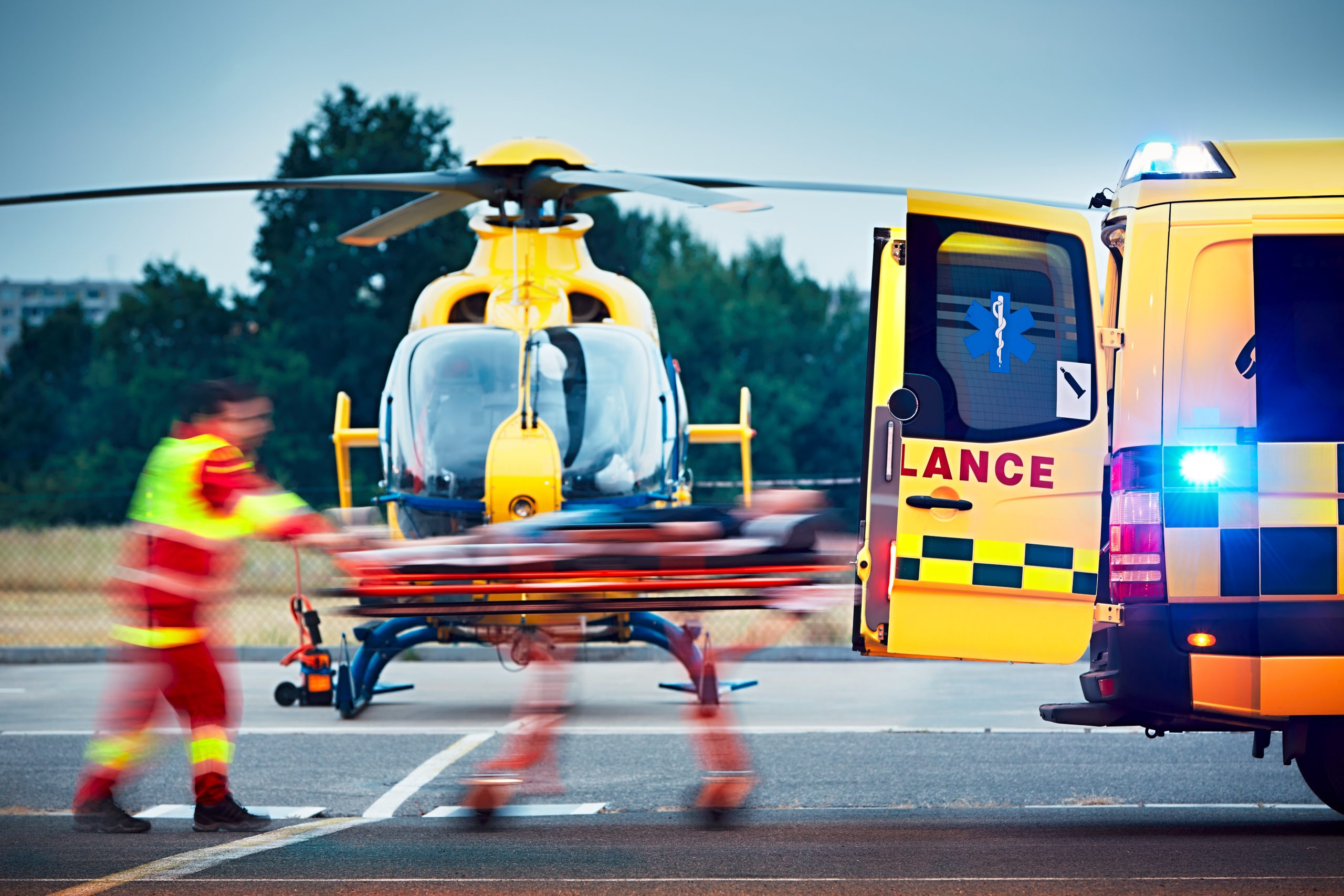 Air ambulance helicopter and ground ambulance coordinating emergency medical patient transfer.
