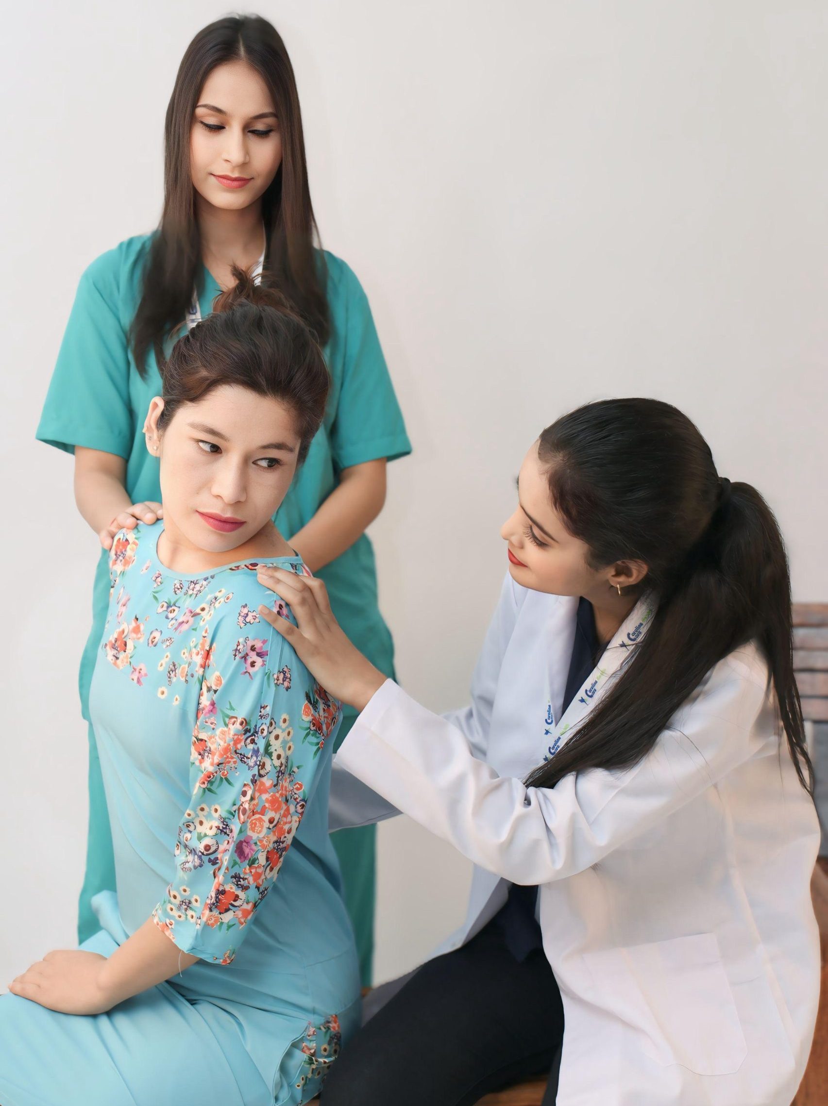 Physiotherapist assisting a patient with shoulder rehabilitation exercise under clinical supervision.